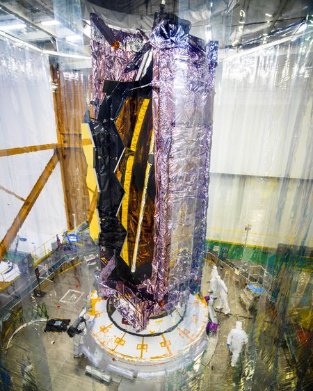 The folded telescope sits upright before being encased in a rocket