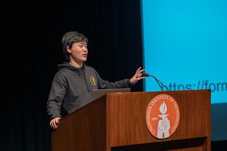 Aaron Zhao speaks behind a podium