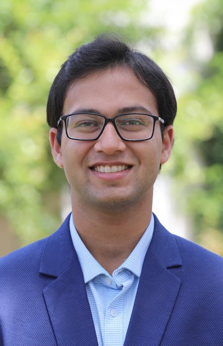 Aniket with trees behind him.
