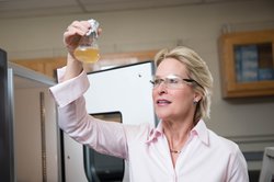 Frances Arnold looks into a chemical flask.