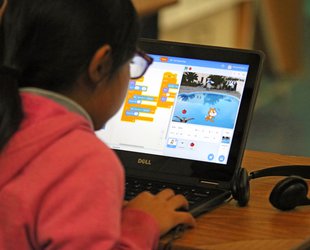 A Pasadena elementary school student practices coding with help from Caltech computer science students.