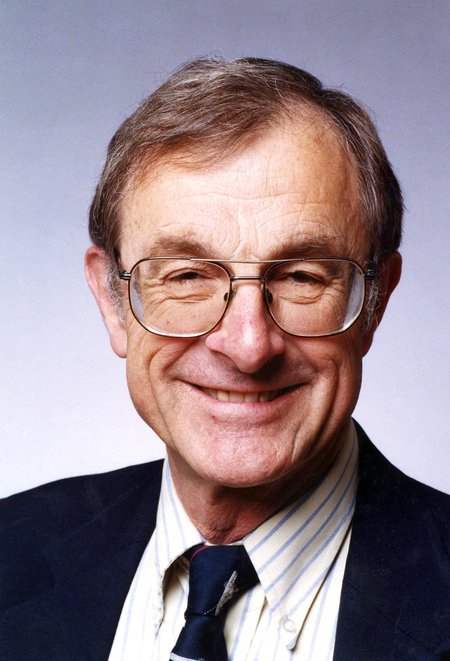 A portrait of Fred Culick. He wears glasses, a shirt, tie, and jacket.