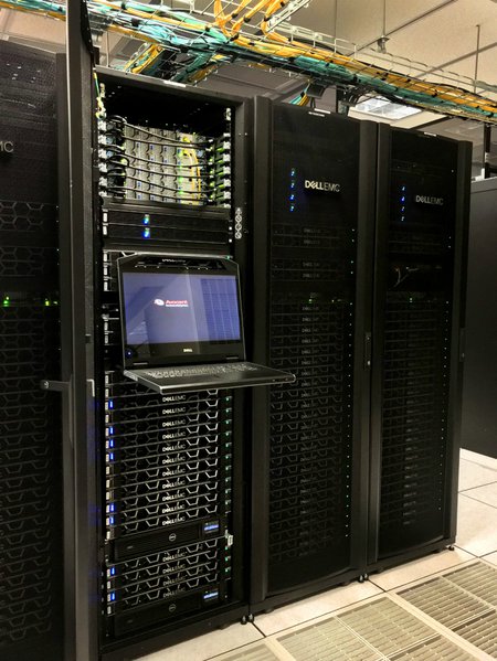 Stack of computers in a tall black case with a column of glowing lights.