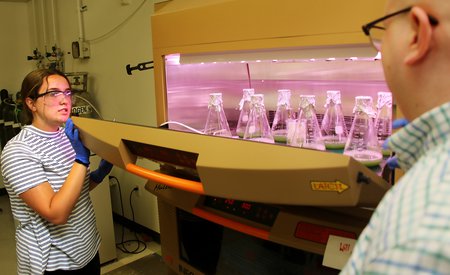 Maggie Higginbotham, a 10th-grade student at Blair High School in Pasadena, opens an incubator shaker to reveal cultures of bacteria used to produce gas vesicles for research.