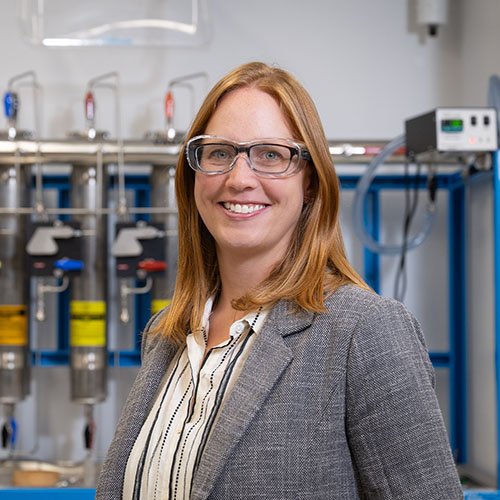 Image of Kimberly See in lab wearing glasses and grey blazer