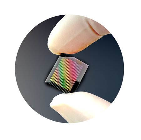 an electronic chip held between two gloved fingers