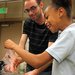 Caltech graduate student Michael Mazza helps a fourth-grade student strain strawberry pulp to extract its DNA.