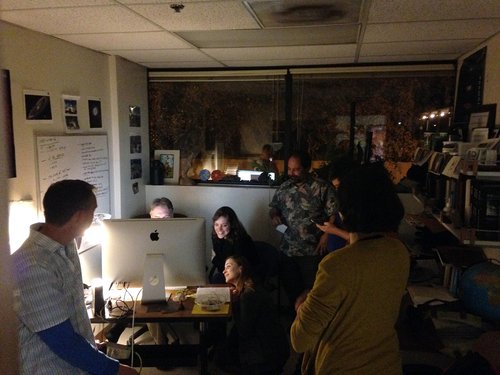 Team members huddle around a computer to watch the first NEOWISE images come in, after it was reactivated in 2013.