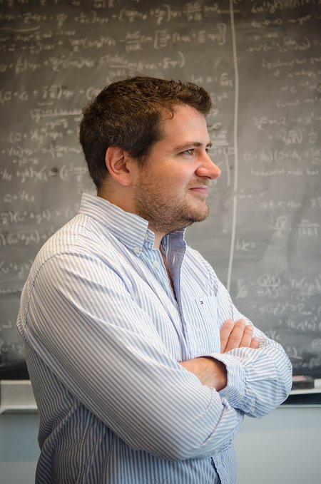 Phil Hopkins standing in front of a chalkboard with equations