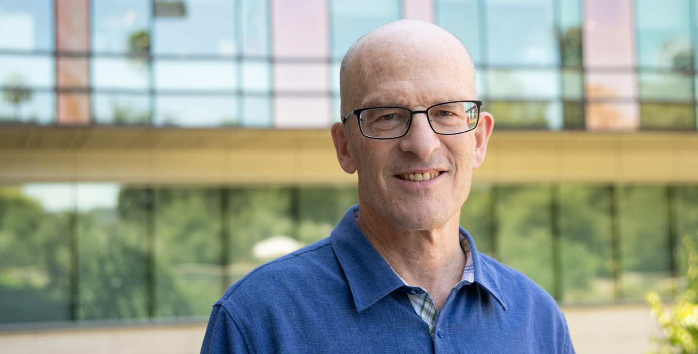 A man with a blue shirt outside of a Caltech building