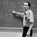 A man standing next to a blackboard