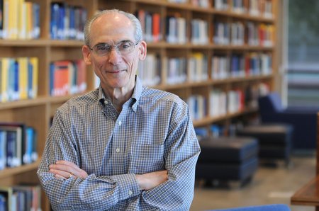 A man standing in front of a bookshelf