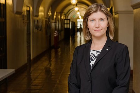 A woman in a black blazer in the hallways of a Caltech building