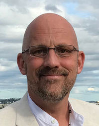 A portrait of Tim Colonius in front of a partly cloudy sky.