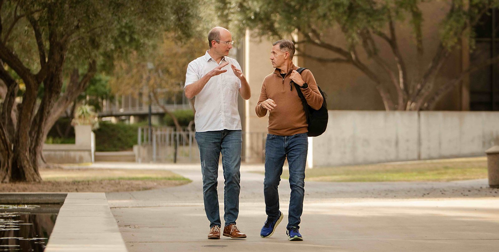 Friedrich Eberhardt and Michael Alvarez converse with each other while walking on Caltech's campus.