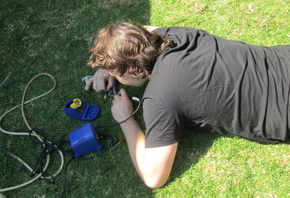 A student repairs a part of a robot his team built for the ME72 competition