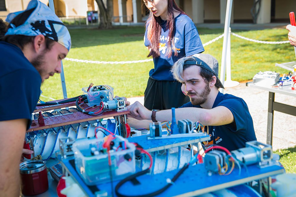 A student team repairs the robot they built for ME72