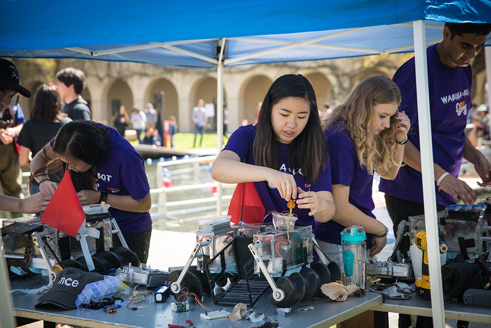 A student team repairs the robot they built for the ME72 competition